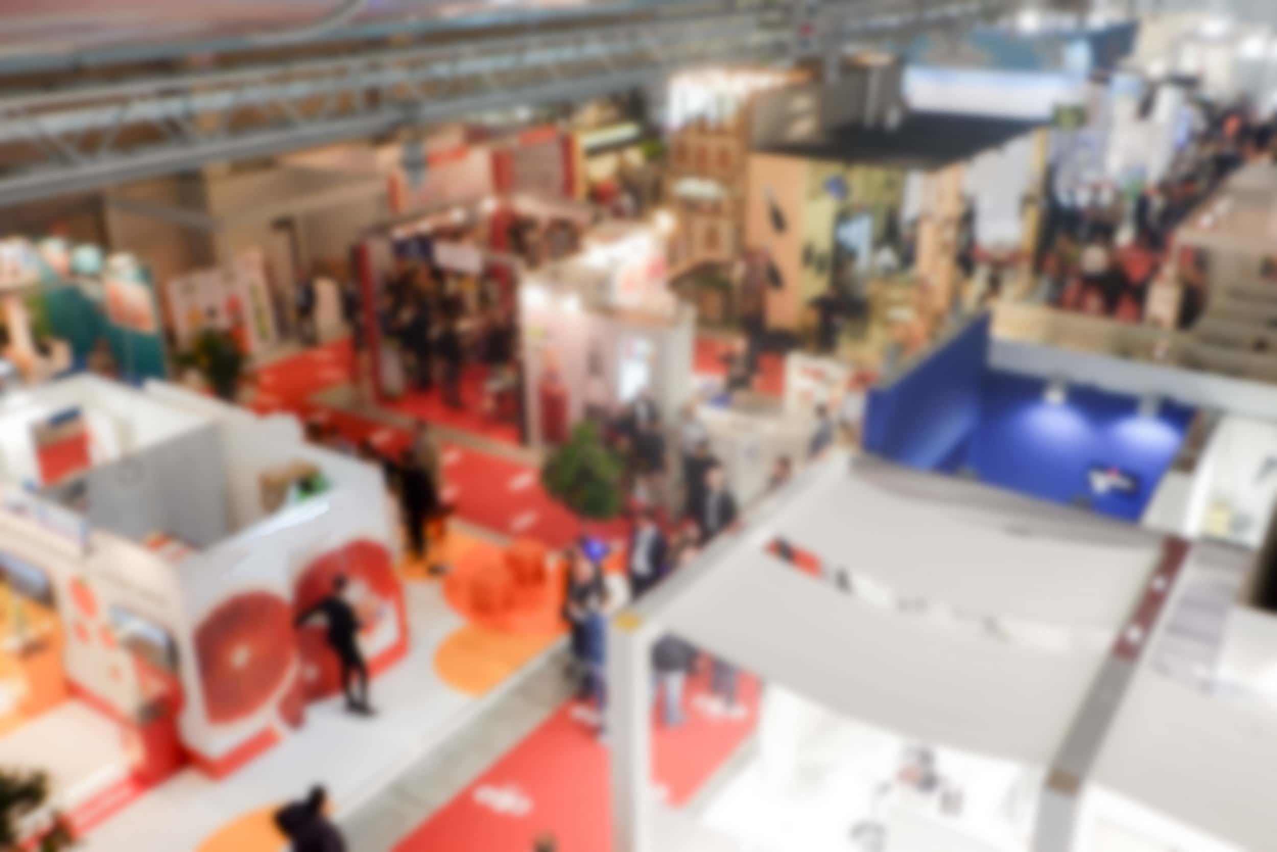 Defocused background of the Pack Expo trade show with people visiting the commercial exhibition. Intentionally blurred post production for bokeh effect