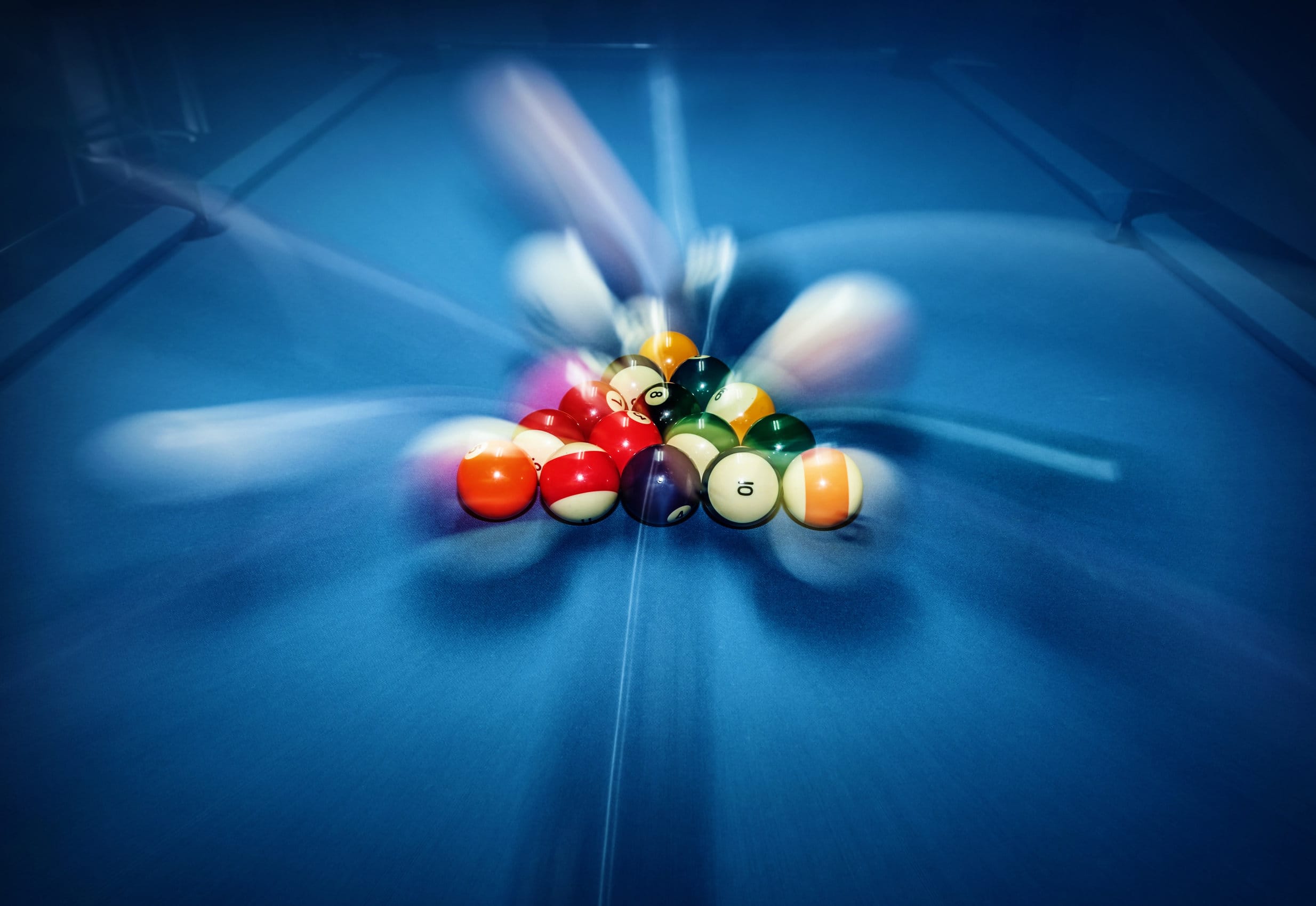 Blue billiard table with colorful balls, beginning of game, slow motion, soft focus, snooker bar, entertainment in nightclub, hobby and sport concept
